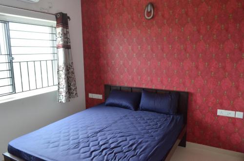 钦奈Oviyam Sea view Apartment, feel like home的一间卧室设有一张床和红色的墙壁
