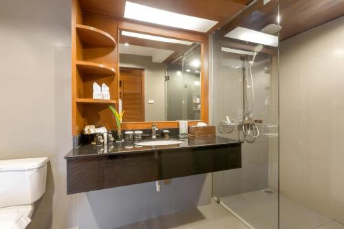 邦涛海滩Best Western Premier Bangtao Beach Resort & Spa的一间带水槽、镜子和卫生间的浴室