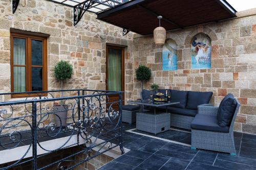罗德镇Chateau Anax Boutique Hotel的石头墙上的庭院配有椅子和桌子
