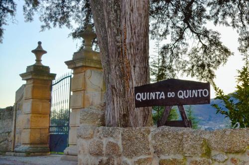 Porto da CarneQuinta do Quinto的栅栏旁树前的一个标志
