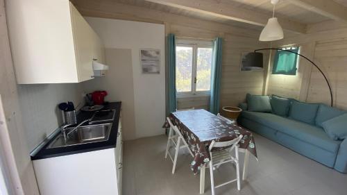 圣多米诺Cottage Mare e Stelle的厨房以及带桌子和沙发的客厅。