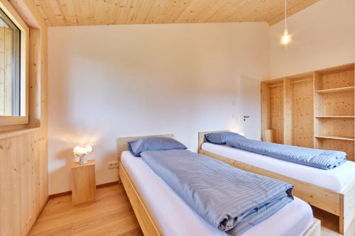 巴特科尔格鲁布Alpinlife Ferienhaus的木墙客房的两张床