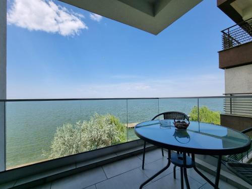 马马亚RoApart Mamaia - Riva Lake Apartments的海景阳台上的桌子