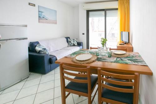 里米尼Residence Villa Dei Pini的厨房以及带桌子和沙发的客厅。