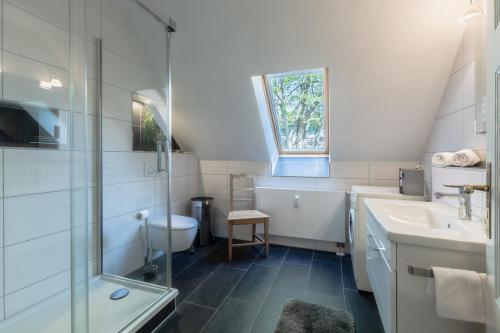 普雷罗Ferienwohnungen am Bernsteinweg的白色的浴室设有水槽和淋浴。
