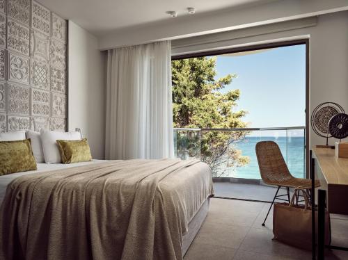 阿凯松Windmill Bay Hotel的一间卧室设有一张床和一个大窗户