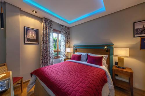 格拉玛多Hotel Boutique Britanico的一间卧室配有一张红色棉被的床