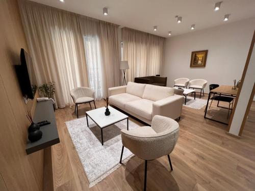 地拉那Habitat Hotel Tirana的客厅配有白色的沙发和椅子