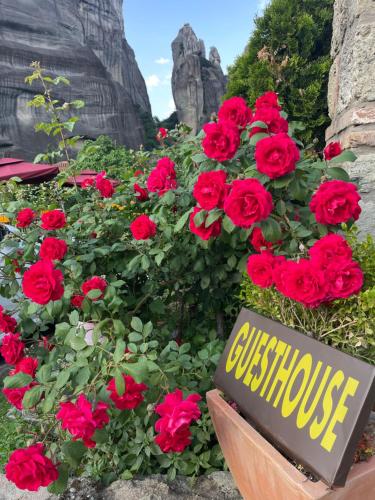 卡兰巴卡Archontiko Mesohori Meteora的红玫瑰花花园里的标志