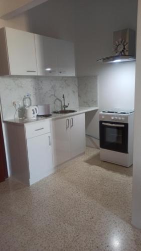 QrendiIL bejta的厨房配有白色橱柜、水槽和炉灶。