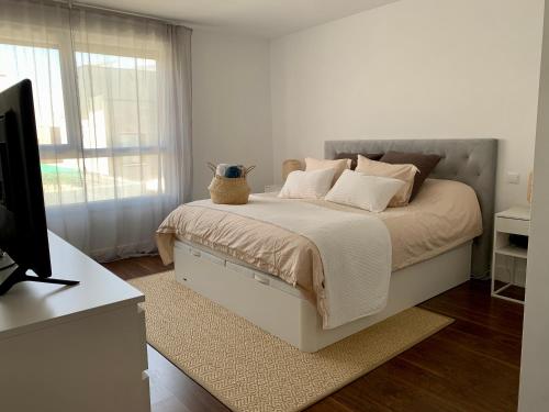 马德里Agradable chalet con piscina privada cerca de Madrid的白色卧室,配有带花瓶的床