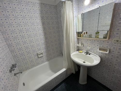 布宜诺斯艾利斯palermo frente al Zoo的浴室配有盥洗盆、浴缸、卫生间和盥洗盆。