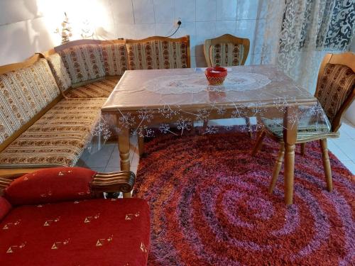 波德戈里察Airport home Radinovic的一张餐桌和椅子,红色地毯
