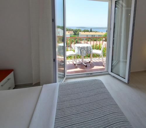 赫瓦尔Guest House Mediterranean的一间卧室配有一张床,阳台配有桌子