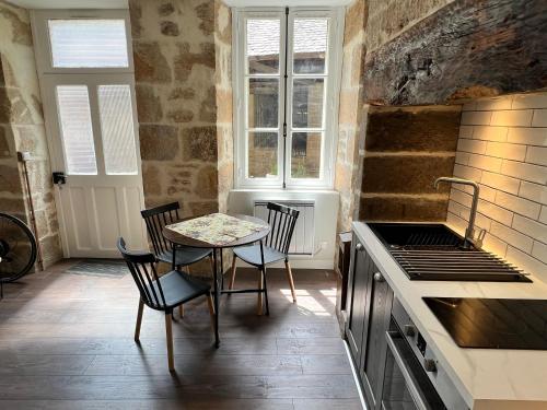 TreignacTreignac Place Studio的厨房配有桌椅和炉灶。