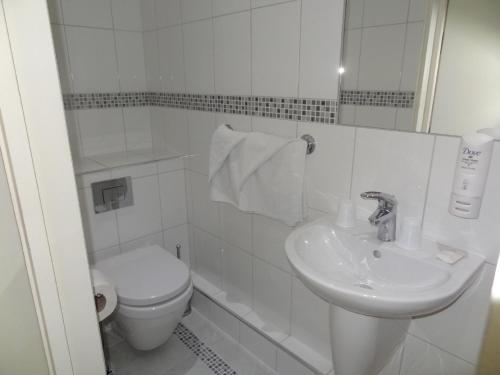 伦敦优尼科酒店的白色的浴室设有卫生间和水槽。