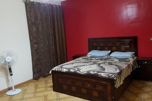 开罗Fantastic Apartment Near Cairo Airport的一间卧室设有一张床和红色的墙壁