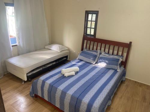 布希奥斯Hostel Blue House Búzios的一间卧室配有两张带蓝白色床单的床
