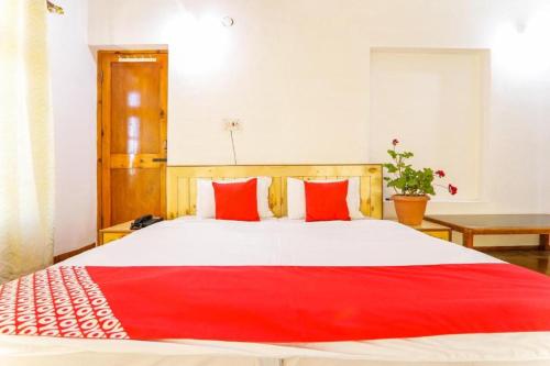 列城Semskit Guest House的一间卧室配有一张带红色枕头的大床