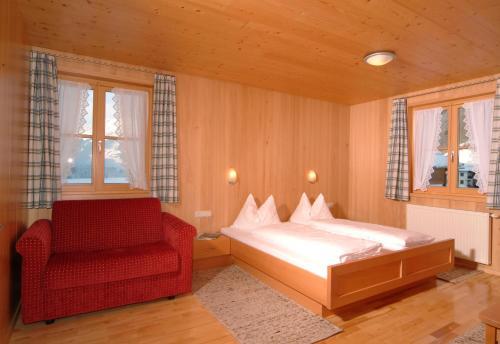 施科佩尔瑙Haus Schatz的一间卧室配有一张床和一张红色椅子