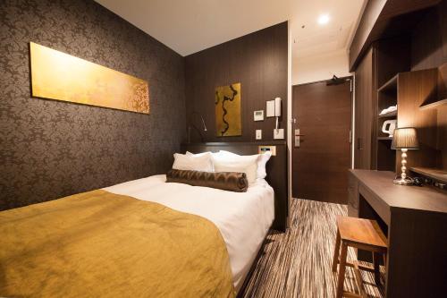 东京赤阪百夫长酒店的酒店客房设有一张大床和一张书桌。