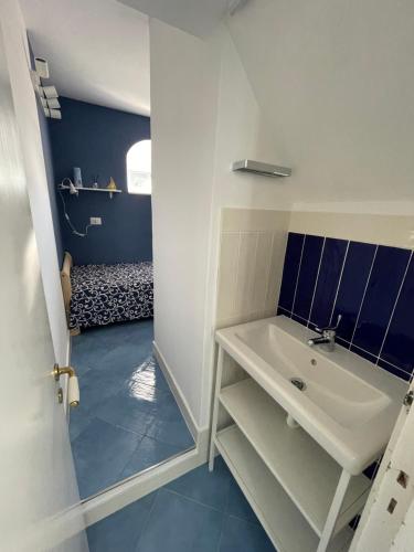 阿纳卡普里Attico Panoramico的浴室铺有蓝色地板,配有白色水槽。