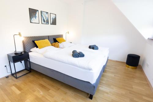 兰施泰因Lahn-Living III - modernes und helles Apartment mit Top Ausstattung的一间卧室配有带白色床单和黄色枕头的床。