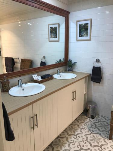 德文港Silwood Apartment fully self contained with Kitchen and Laundry的一间带两个盥洗盆和大镜子的浴室