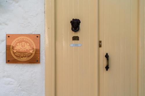 伊兹拉Rafalias Mansion的墙上有标牌的门
