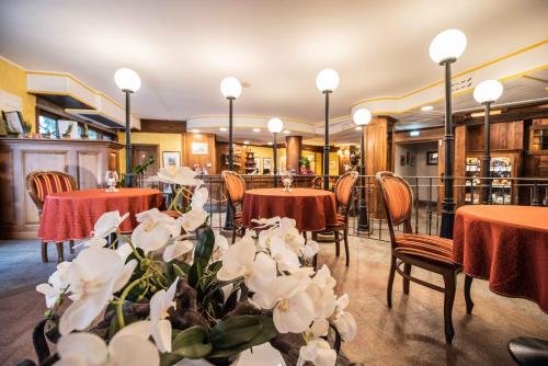 夏特林瑞蕾斯度酒店的一间设有桌椅的餐厅,并种植了白色的鲜花