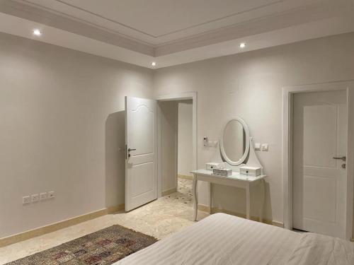 利雅德سمو 4的白色卧室配有床和镜子