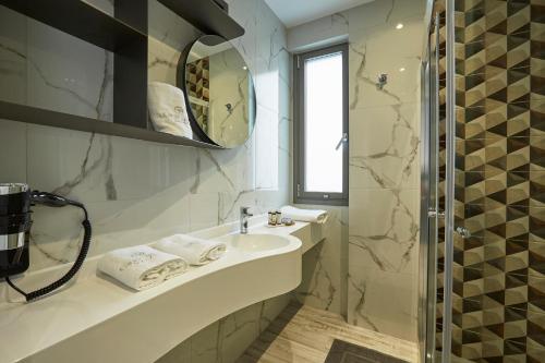 帕拉利亚狄奥尼索GreyStone Suites的白色的浴室设有水槽和镜子