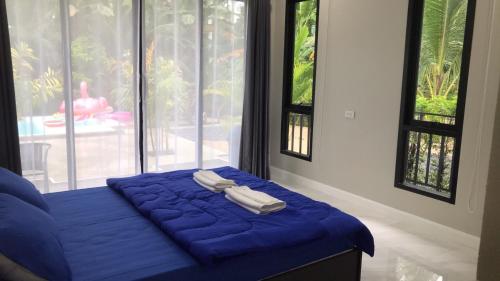 Ban Na KlangPool Villa Nita的蓝色的床,上面有两条毛巾