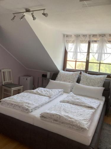 卡尔斯塔特Ferienwohnung Knittel的一间卧室配有一张带白色床单的床和一扇窗户。