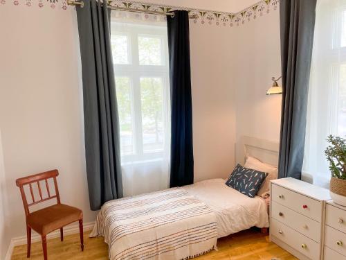 派尔努Spacious Supeluse Apartment的卧室配有床、椅子和窗户。