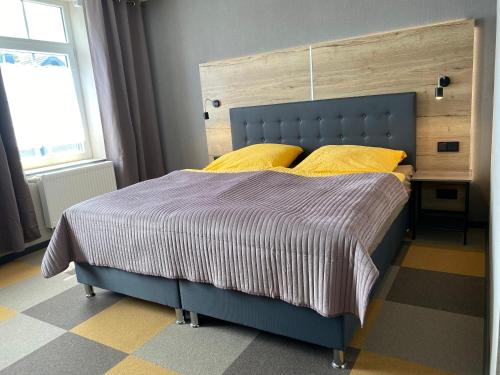 蒙绍Gästehaus Bendsieferhof的卧室内的一张带黄色枕头的蓝色床