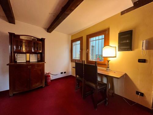 威尼斯艾博特利酒店的客房设有带台灯和窗户的书桌。