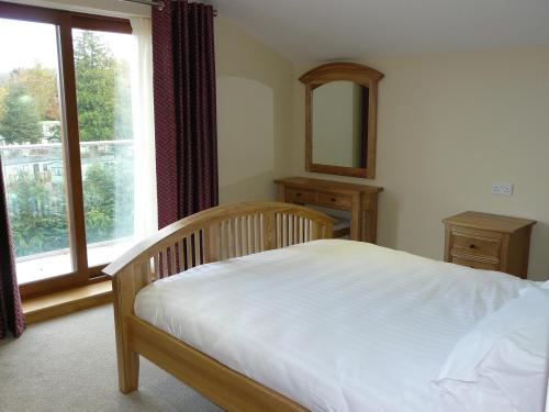 彭里斯Cherry Lodge的一间卧室设有一张床和一个大窗户