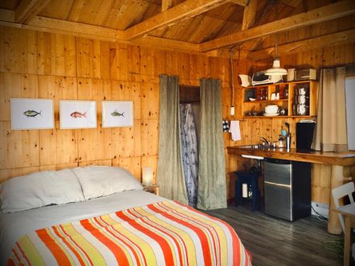 博纳旺蒂尔Auberge Café Acadien的木制客房内的一间卧室,配有一张床