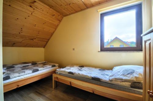 伊斯泰布纳Słoneczne domki 2的带窗户的客房内的两张床