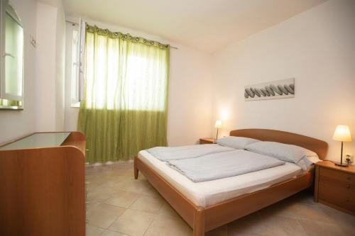 布雷拉海景公寓的一间卧室配有床和绿帘