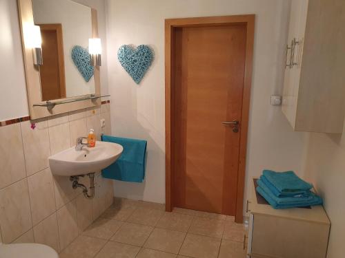 普劳西Villa Seeschwalbe Plau的一间带水槽的浴室和一扇墙上的心门
