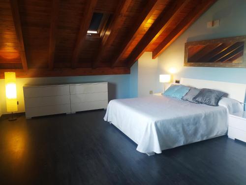 Morillo de MonclúsCasa Rural Tejedor的卧室设有白色的床和木制天花板。