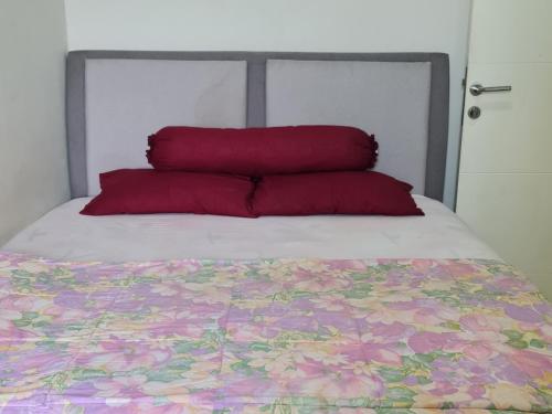 贝克西Apartemen Springlake Summarecon Bekasi-By Bu Johan的床上有两个红色枕头的床