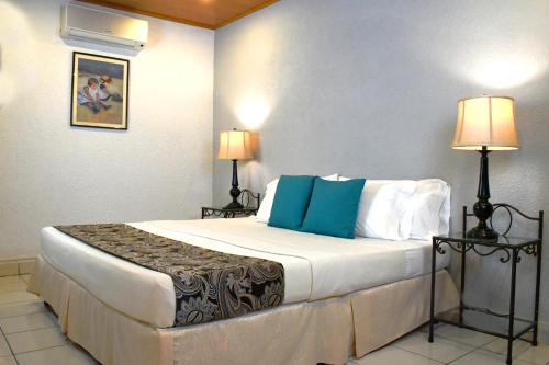 马塔加尔帕Hotel San Jose, Matagalpa.的酒店客房配有一张带蓝色枕头的大床