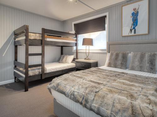 金德拜恩Chalet Alpina的一间卧室配有两张双层床和一盏灯。
