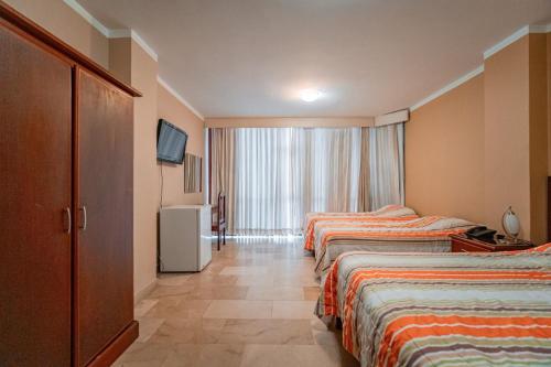 Huaquillas索尔德尔苏尔酒店的酒店客房设有两张床和电视。