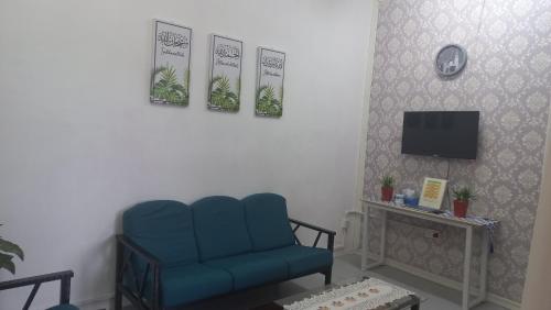 马日丹那BenBahrains Homestay - PB - ISLAMIC COMPLIANCE ONLY的客厅配有蓝色椅子和电视
