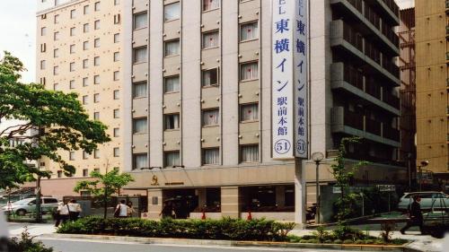 横滨Toyoko Inn Shin-yokohama Ekimae Honkan的前面有标志的建筑