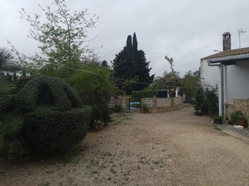 L'AldeaCasa Rural Masia d'en Gall的房屋前有灌木的院子